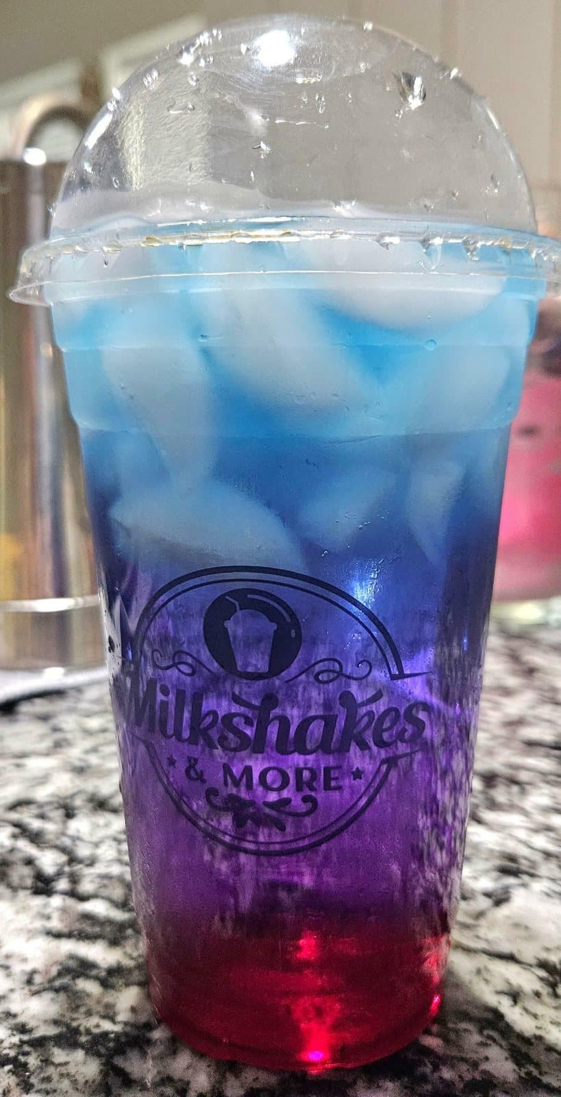 Layered dragonfruit butterfly pea tea in a Milkshakes & More cup