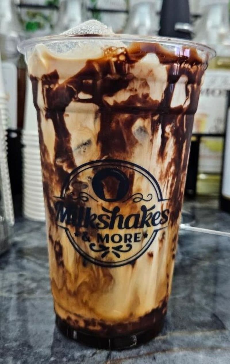 Iced mocha latte with chocolate drizzle in a Milkshakes & More cup